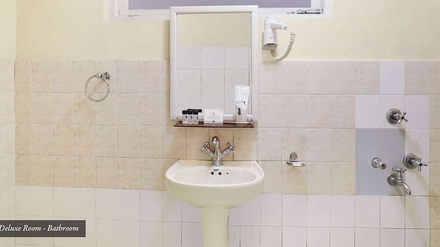 A wash basin and a mirror hung on the wall | Summit Newa Regency & Spa, Pelling