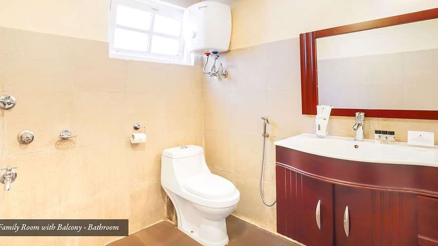 A commode in a bathroom that has a wash basin and a mirror on the wall | Summit Newa Regency & Spa, Pelling