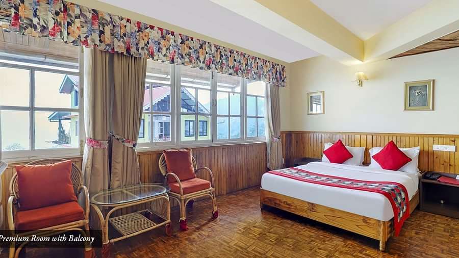 A room with a bed, chairs, and a glass window | Summit Newa Regency & Spa, Pelling