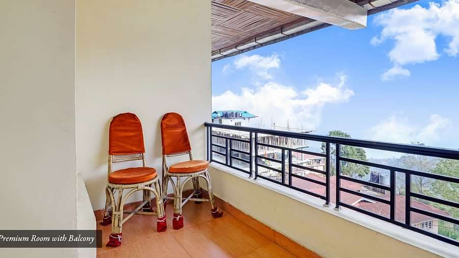 Two chairs placed on a balcony that has a backdrop of blue sky | Summit Newa Regency & Spa, Pelling