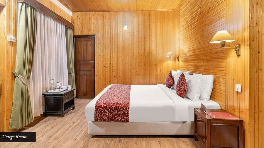 Side view of a room with bed and a table besides it at Summit Tashi Ghang Heritage Resort, Pelling