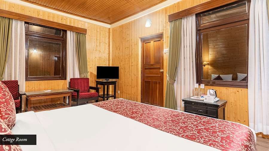 Image of a room with bed and windows on two sides on the room at at Summit Tashi Ghang Heritage Resort, Pelling