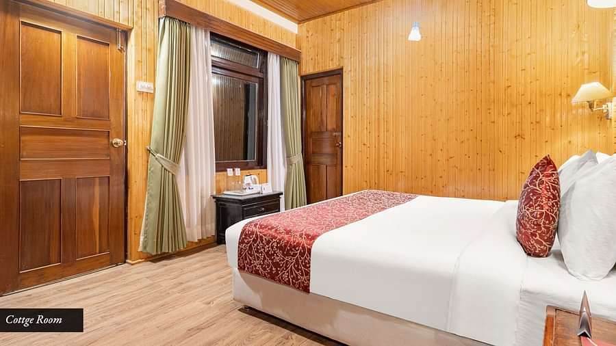 Side view of a room with bed and wooden wall panelling at Summit Tashi Ghang Heritage Resort, Pelling