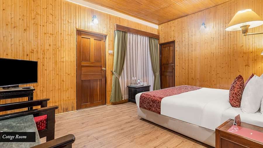 Image of a room with bed and a television in the corner at at Summit Tashi Ghang Heritage Resort, Pelling