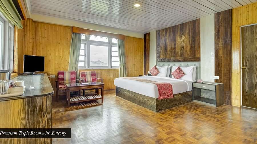 Room with a large bed and sitting area at Summit Tashi Ghang Heritage Resort, Pelling