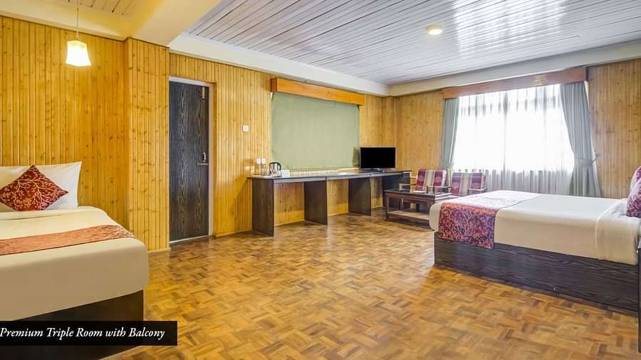 Room with two beds and wooden wall panelling at Summit Tashi Ghang Heritage Resort, Pelling
