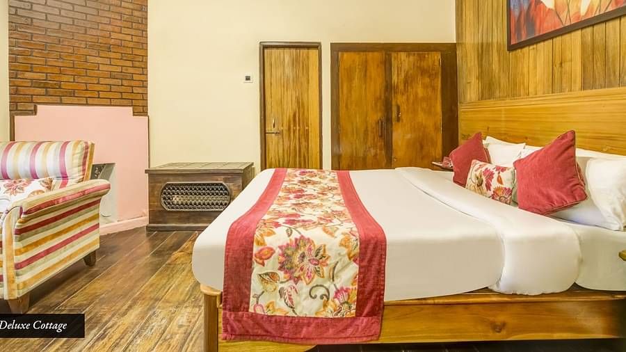 Deluxe cottage at Summit Barsana Resort & Spa, Kalimpong with a double bed and a wardrobe