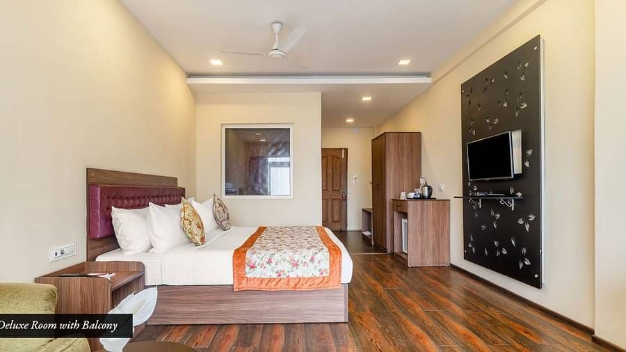 Deluxe room at Summit Barsana Resort & Spa, Kalimpong with a double bed