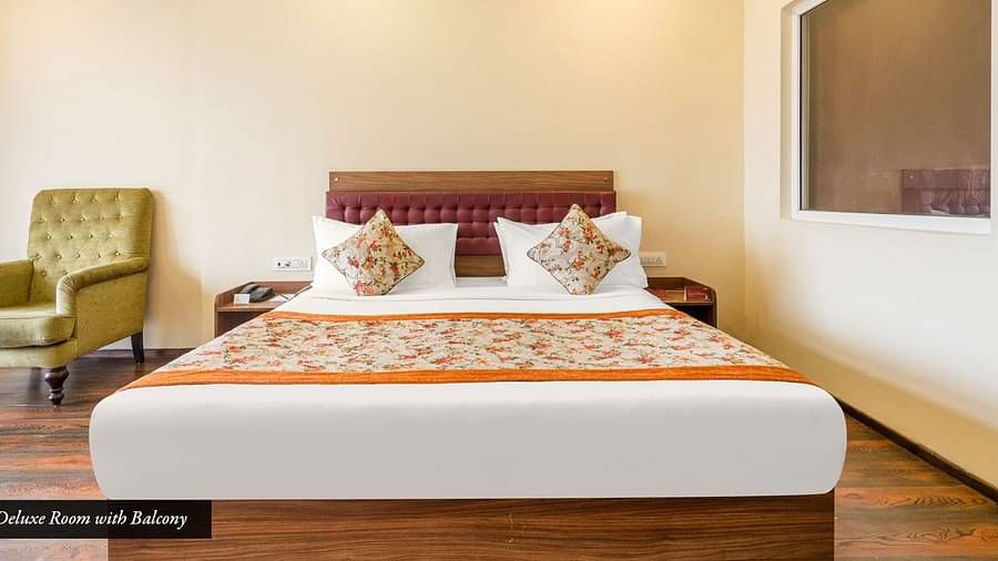 Deluxe room at Summit Barsana Resort & Spa, Kalimpong with a double bed