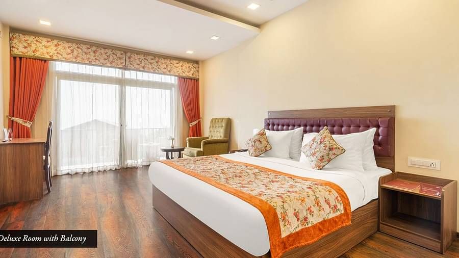 Deluxe room at Summit Barsana Resort & Spa, Kalimpong with a double bed