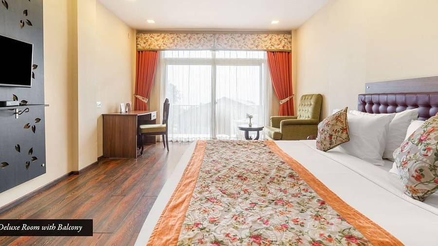 Deluxe room at Summit Barsana Resort & Spa, Kalimpong with a double bed