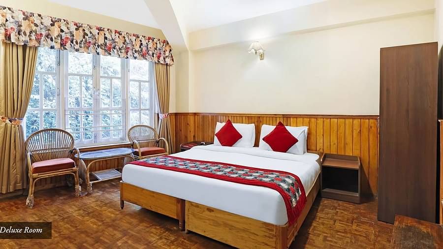 A full view of a room that has a bed and a huge glass window | Summit Newa Regency & Spa, Pelling