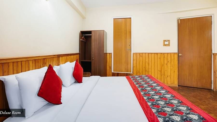A side view of a bed in a room that has a wardrobe | Summit Newa Regency & Spa, Pelling