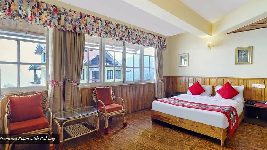 A room with a bed, chairs, and a glass window | Summit Newa Regency & Spa, Pelling