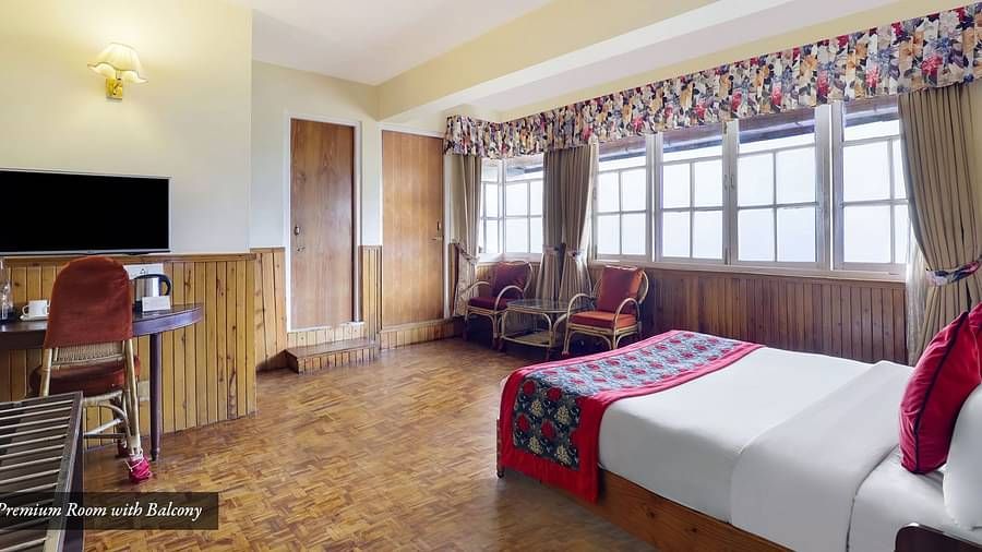 A room that has a bed, chair, TV, and a glass window | Summit Newa Regency & Spa, Pelling