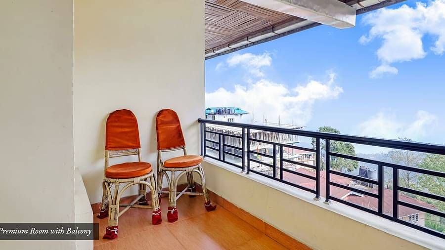 Two chairs placed on a balcony that has a backdrop of blue sky | Summit Newa Regency & Spa, Pelling