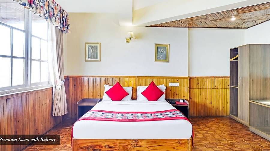 A front view of bed in a room with a glass windows | Summit Newa Regency & Spa, Pelling