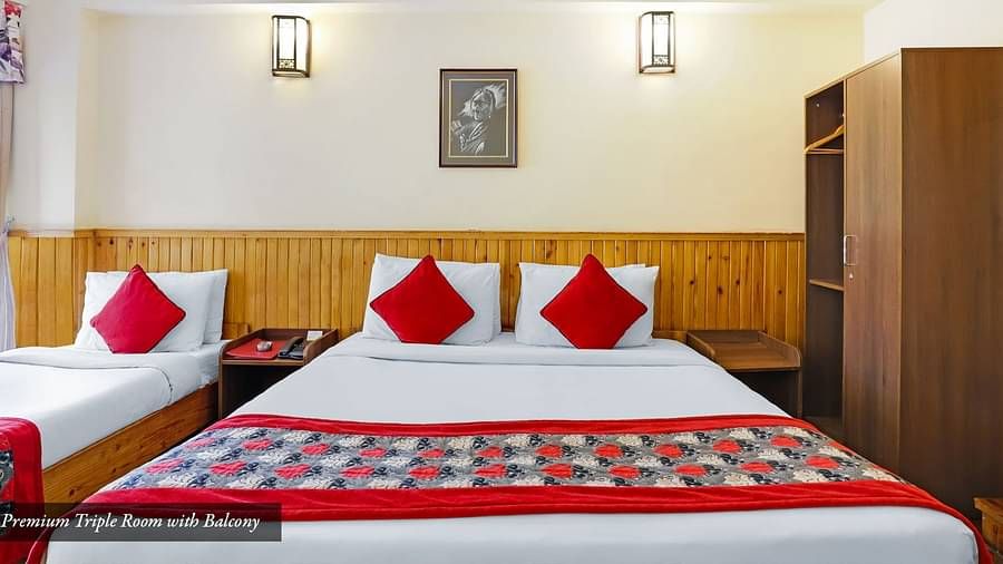 A front view of the beds placed in a room that has a glass window | Summit Newa Regency & Spa, Pelling