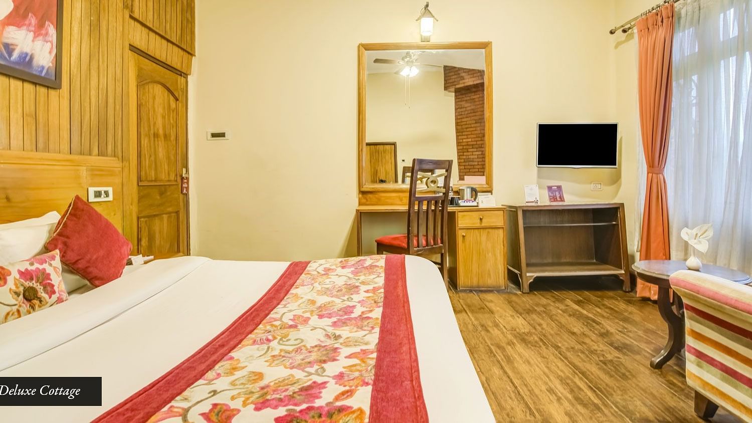 Deluxe cottage at Summit Barsana Resort & Spa, Kalimpong with a double bed and a television