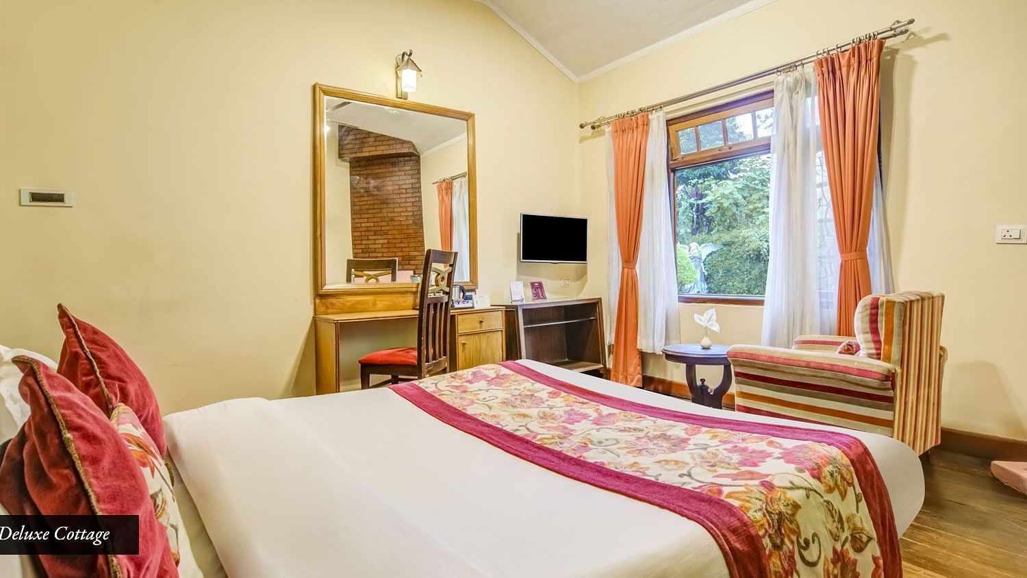 Deluxe cottage at Summit Barsana Resort & Spa, Kalimpong with a double bed and a work desk and chair