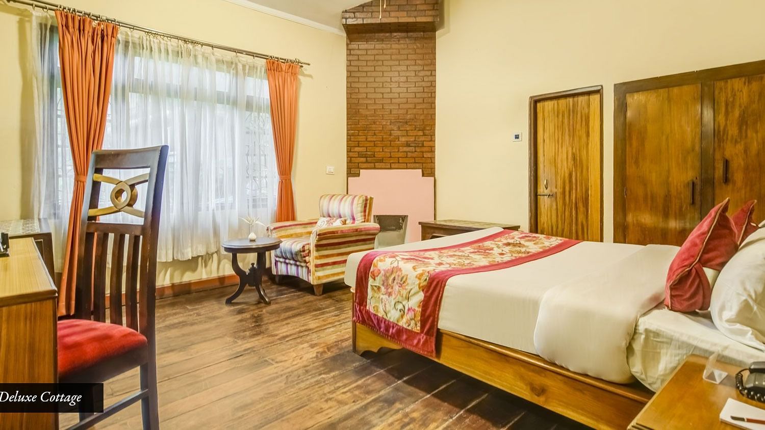 Deluxe cottage at Summit Barsana Resort & Spa, Kalimpong with a double bed and a work desk and chair