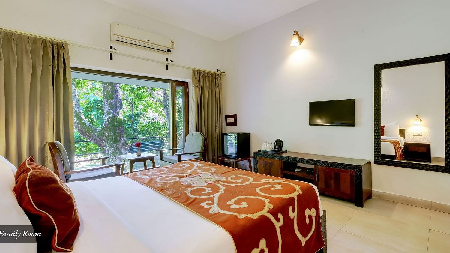 Image of a family room with bed a larg mirror at Summit By The Ganges Beach Resort & Spa, Rishikesh