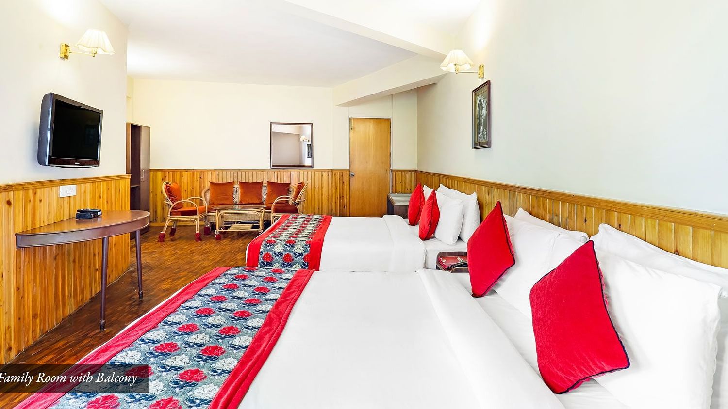 A side view of beds placed in a row in a room that has TV on the wall | Summit Newa Regency & Spa, Pelling