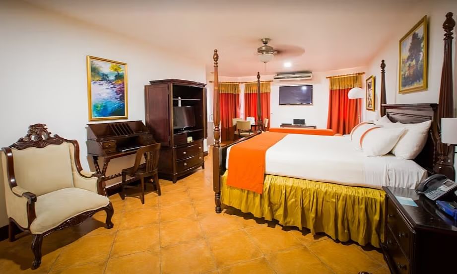 tiled bathroom shows a bathtub, a vanity with two sinks, and a walk-in shower | Alexander Suite | Altamont Court, Jamaica