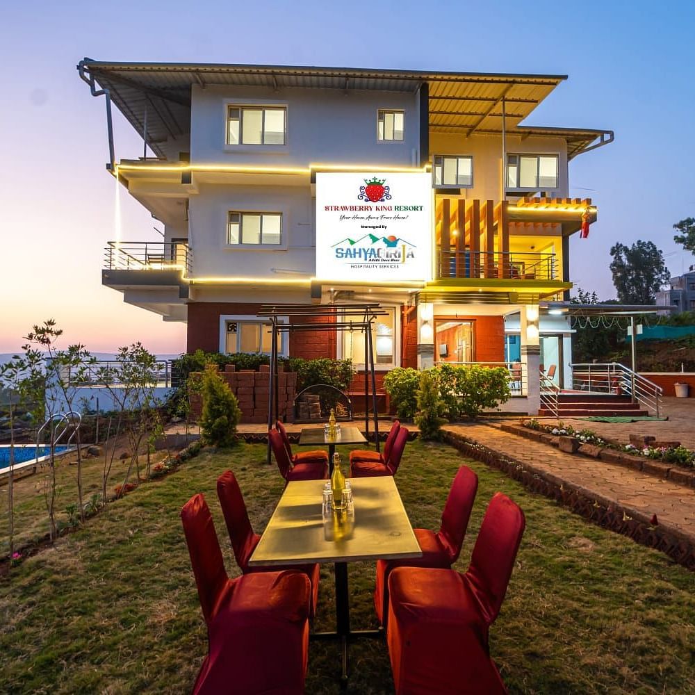 An exterior view of Strawberry King Resort, Mahabaleshwar with outdoor seating.