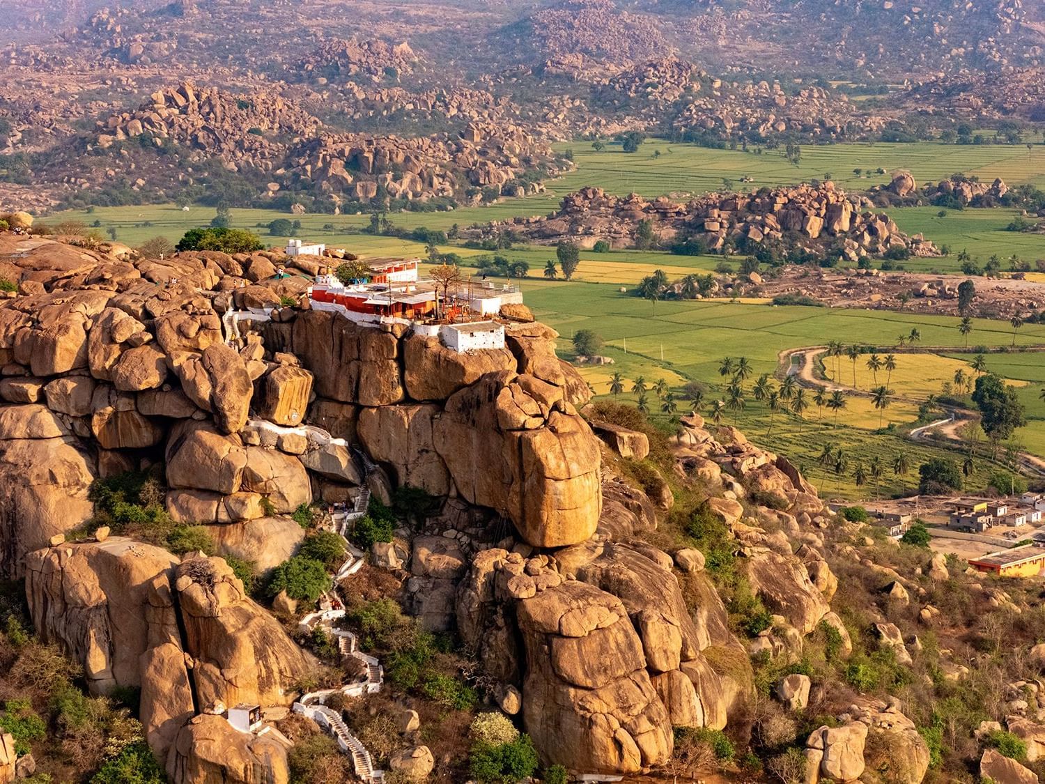 Aerial view of the rocky terrain and lush landscapes of Anegundi, part of the Anegundi Trail experience at Evolve Back, Hampi.