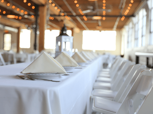 a view of a white table and chair set for dining perfect to host events in Pollachi