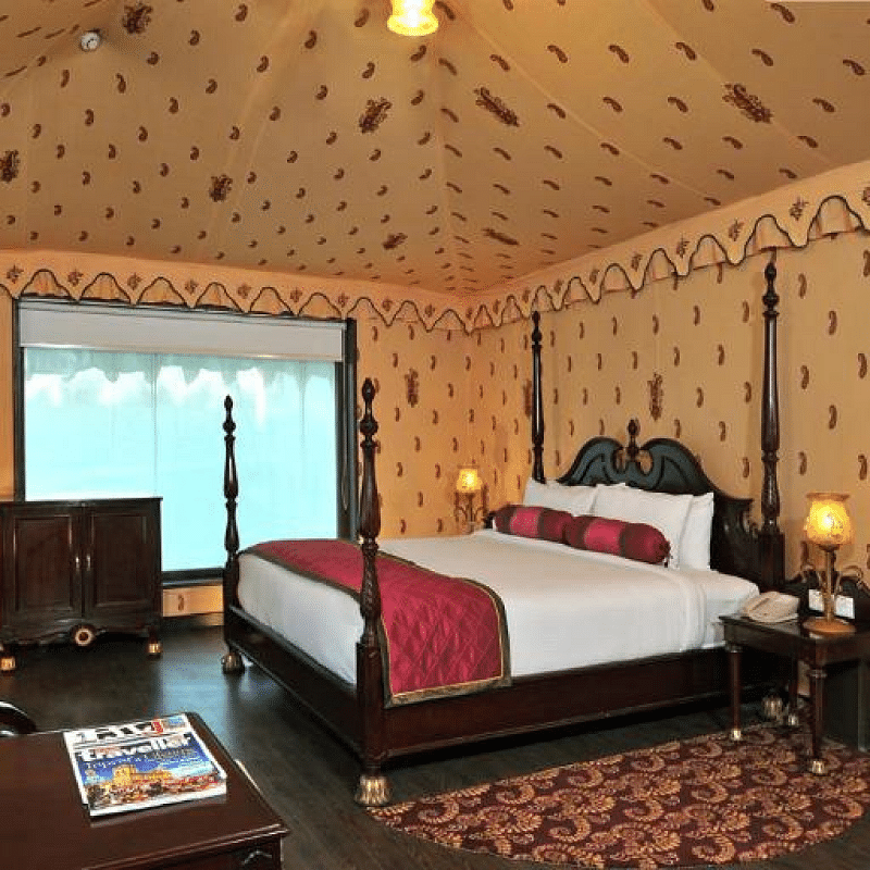 Side view of a room with a bed and a television in front of the bed at Rajasthali Resort & Spa Jaipur.