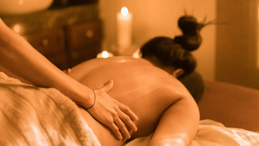 Person receiving a back massage in a spa room at Karma Chalets.