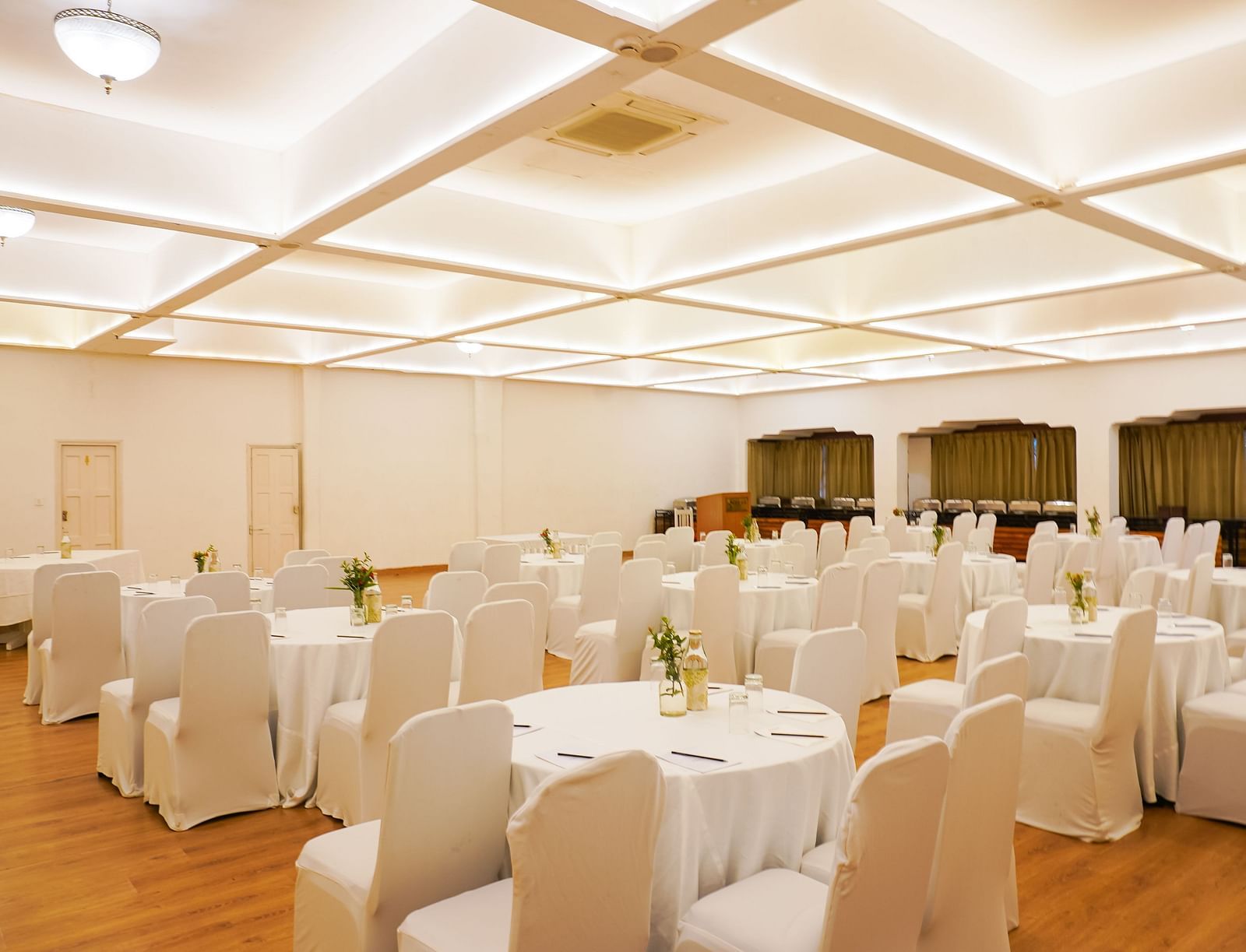 Seating arrangement in a banquet hall at Saraca Hotel, Lucknow with white lighting