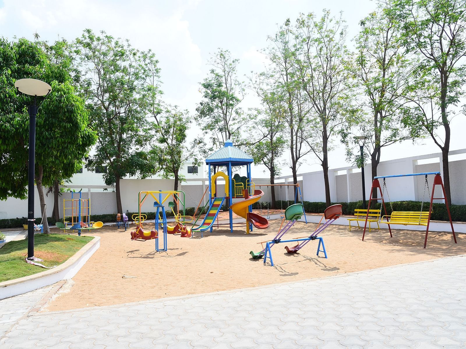 A well-maintained children's playground with swings and slides, providing a fun outdoor space.- Dhanalakshmi Srinivasan Hotels, Perambalur