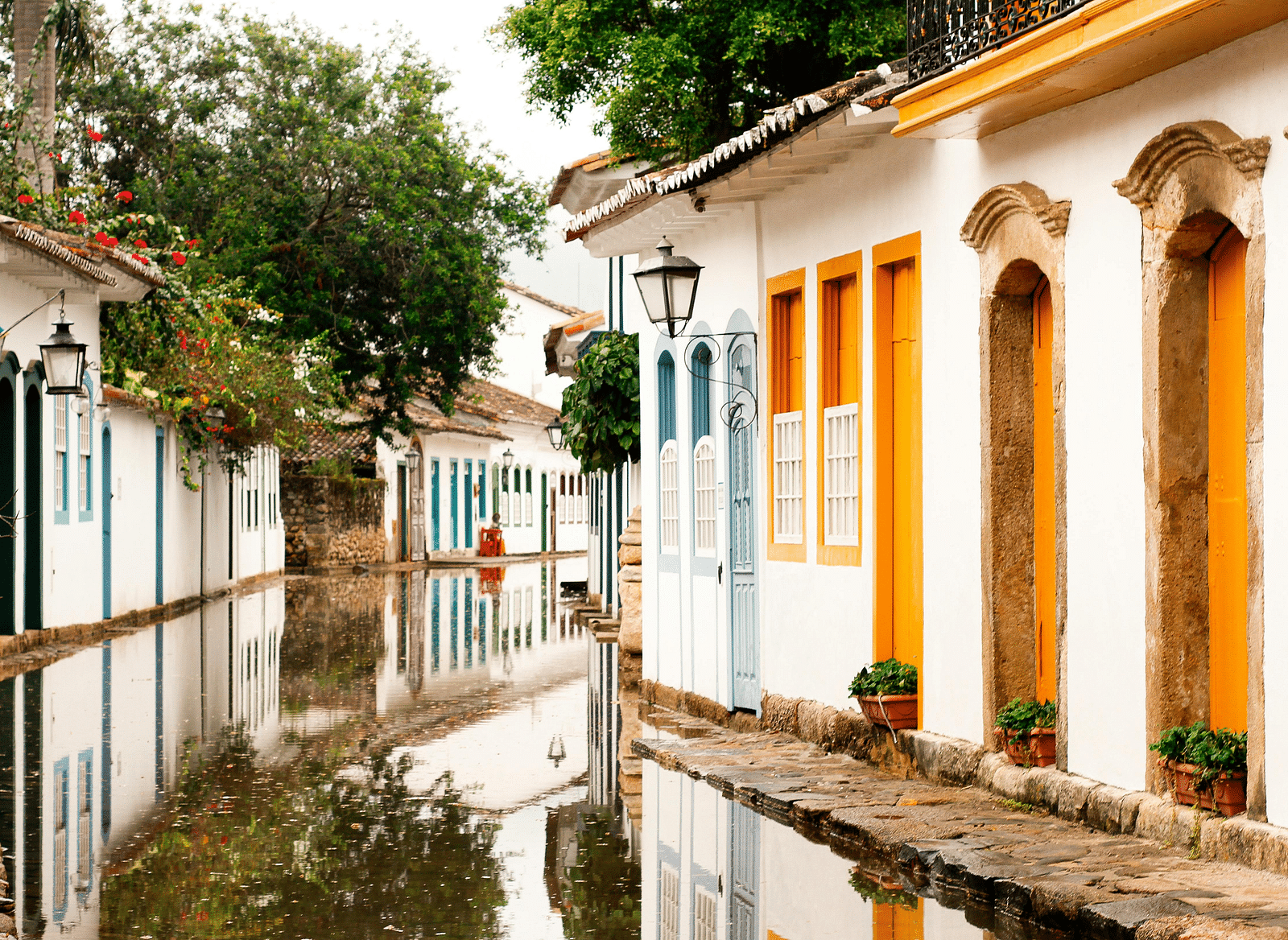 Colonial-style buildings line either side of the pathway, their reflections mirrored in the water.