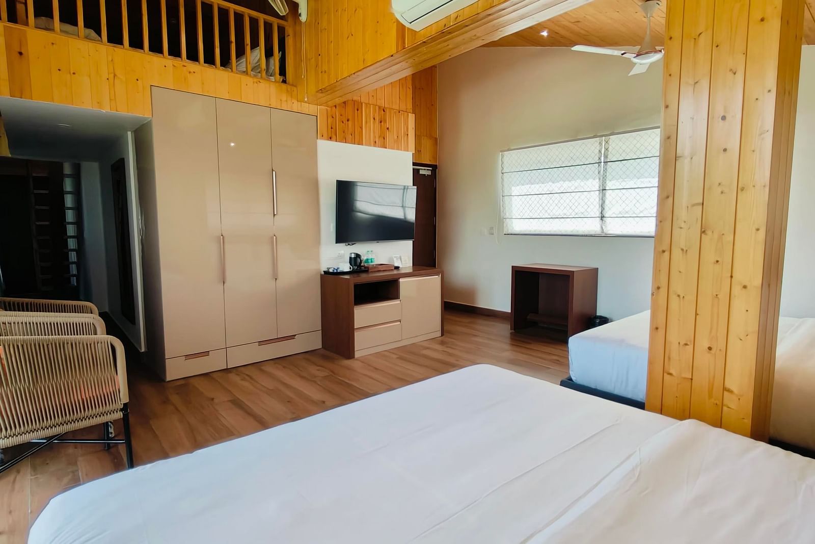 a family suite with wooden interiors at Eminence The Corbett with two beds in the room