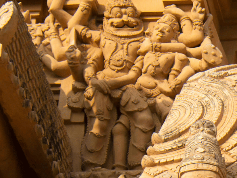 A view of Brihadeeswarar Temple's gopuram having a carving of deity having numerous hands holding another person in a headlock. It is one of the places of interest in Tanjore, for historical and architectural significance.