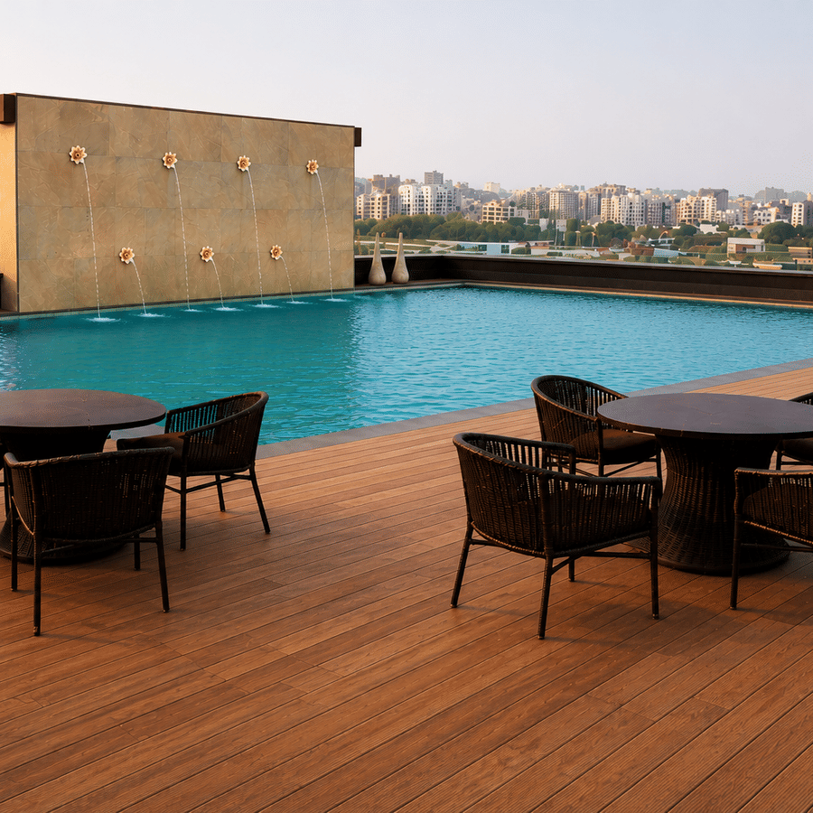 Rooftop pool deck during daytime featuring dark wicker dining sets on a wooden patio at the Adamo Hospitality.