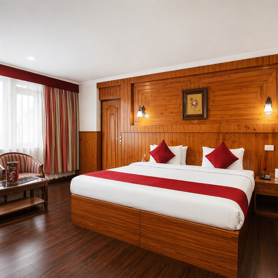 A room at Central Hotels featuring a king bed with red and white bedding wooden wall panels dark hardwood flooring a wooden seating area with chairs and large windows with curtains.