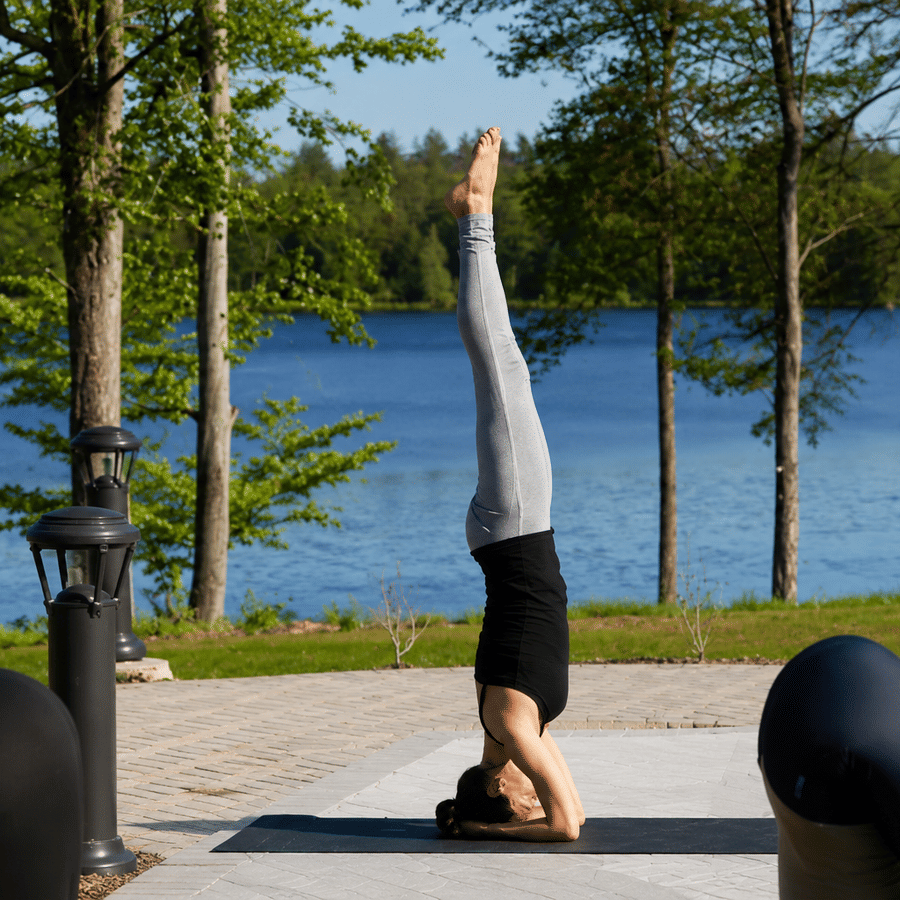 A group of people practicing yoga on a sunny patio at YO1 Longevity and Health Resorts