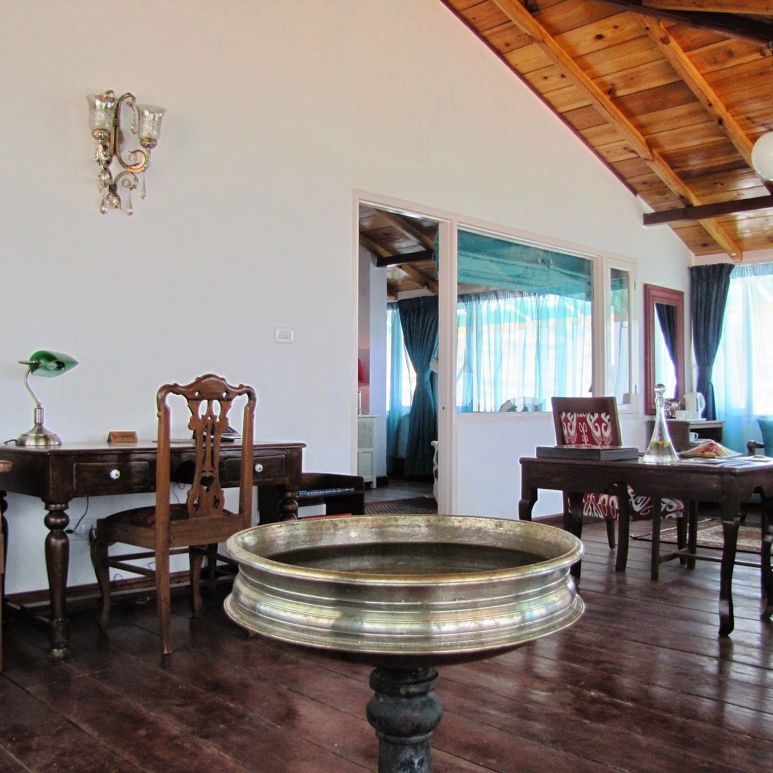Room with table and chairs and wooden ceiling at Te Aroha by Shervani Mukteshwar