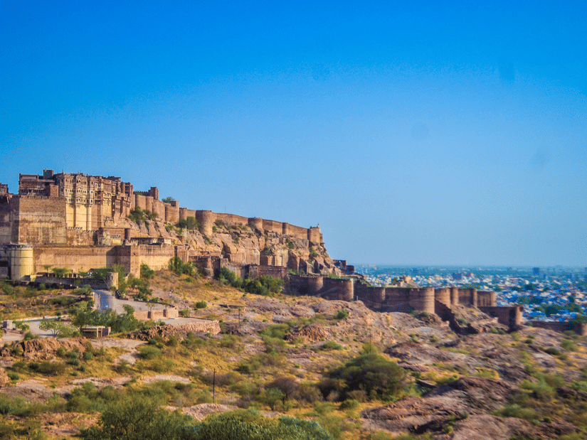 Facade of Mehrangarh Fort under a blue sky with the backdrop of Jodhpur city