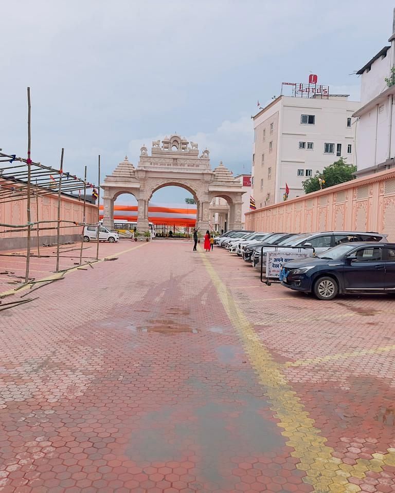A red-paved road leads towards an arched gateway between light-coloured buildings - Kankidham Lords Inn