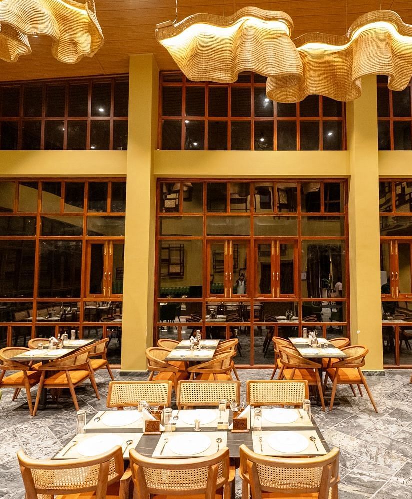 A modern dining space with large windows, stylish furniture, and an inviting atmosphere, designed for a comfortable dining experience - Sea Hills Resort, Swaraj Dweep (Havelock)