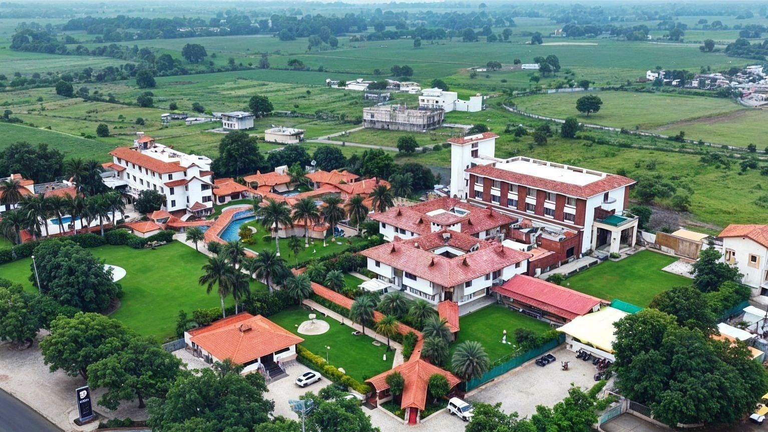 A birds eye view of a large collection of building placed in the middle of some greenery - Crescent Resorts