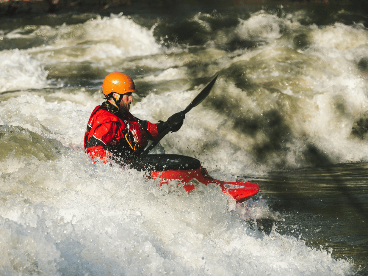 A man rafting with a swaddle through the high waves.