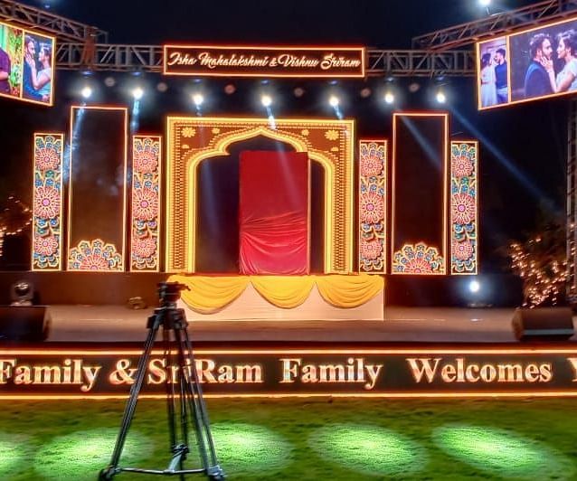 A massive stage setup for events with spotlights in the lawn of GK Hill View Resort at night.