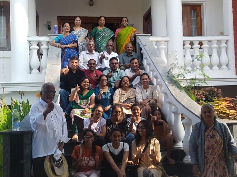 Image of a group of people sitting on the stairs and posing for a photo at Villa Serenity Le Sejour Pondicherry.