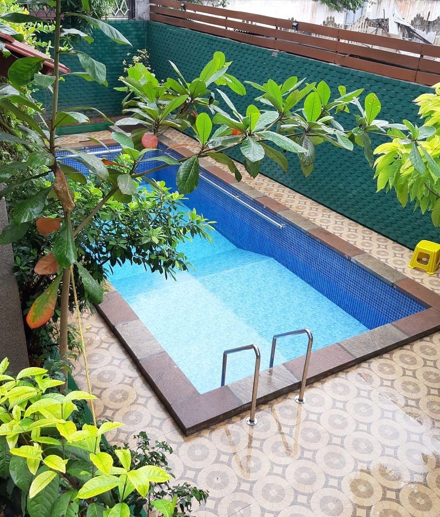 Image of a an outdoor swimming pool with trees on the side at Villa Serenity Le Sejour Pondicherry.